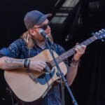 Dave Holmes playing an acoustic guitar