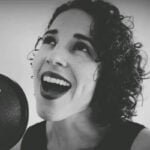 Madeleine Machado singing into a microphone