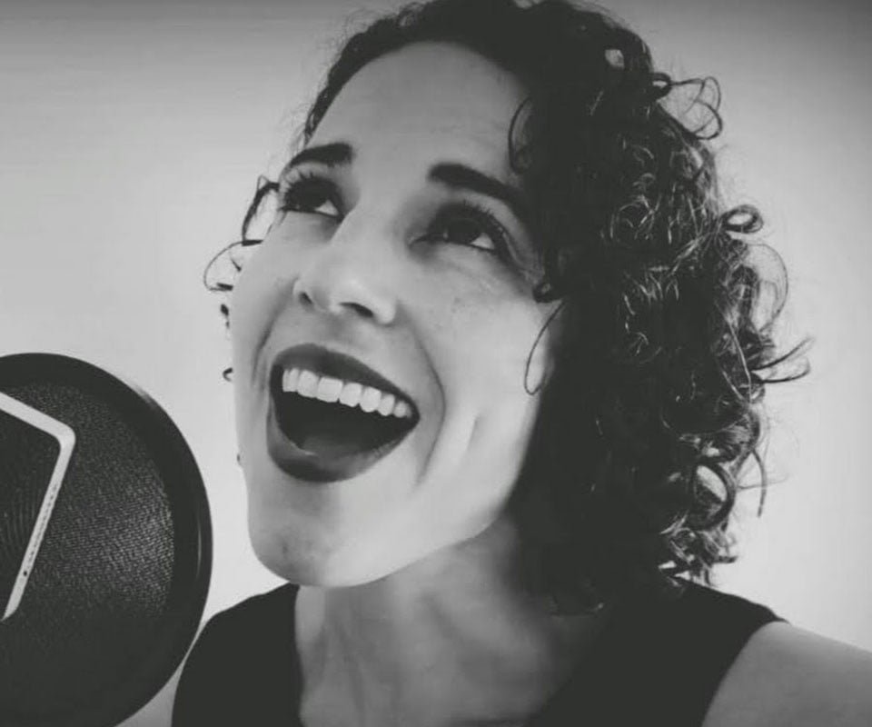 Madeleine Machado singing into a microphone